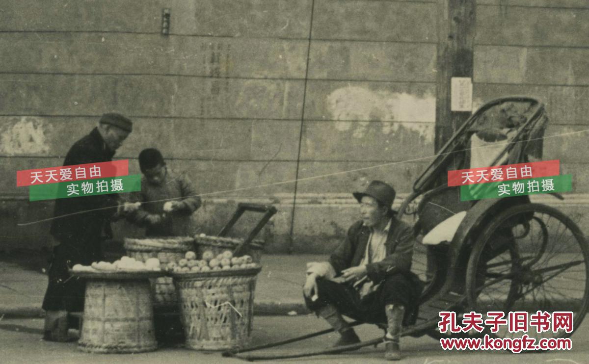 民国上海街头卖水果的小贩和等客人的人力车车夫老照片,可见墙角标语"