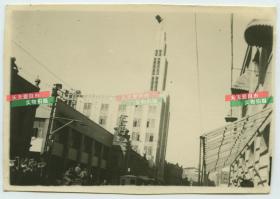 民国时期天津中原百货，塔尖之前失火，照片中是失火后改造的，街道上悬挂国民党旗帜的高楼建筑老照片。拍摄于1945年双十节期间。9.7X6.8厘米