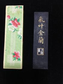 上世纪70，80年代老墨 二两墨块《气叶金兰》1枚，原盒装，保存完整，可能使用过一次。上海墨厂制。正面黄胄题字，背面兰石图。尺寸：11*3cm。