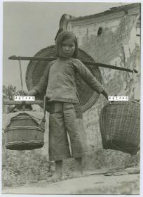 1944年10月中国军队和美国盟军经过五周的激战，从日军手中夺回云南腾冲后，一小女孩挑着木桶和柳条筐，带着家当返回腾冲的老家，小女孩沉重，隐忍而坚毅的目光，就是当时腾冲人民抗日精神的写照。16.6X12厘米