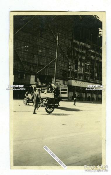 民國時期上海外灘附近正在維修的大樓，有推獨輪車太平車的百姓經過。11.1X6.8厘米，泛銀