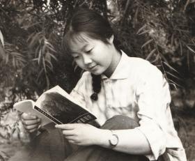 七十年代，佩戴手表，手持72年版摄影知识书本的姑娘