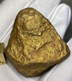 陨石原石，陨金，有磁性，陨金“极美高温融流纹”“水波纹自然金陨金”陨石原石，“狗头金”陨石原石，“黄金水波纹陨石”，密度高，42.3克重，自然界极为稀有，可遇不可求，沉甸甸的，气印、气孔、熔壳包浆完整，非常特别，石质细腻坚硬，色泽油润，石型完整，气印熔流明显，极为稀有罕见，沁色自然，鬼斧神工，收藏之极品