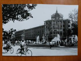 1987年新华社摄影记者李玉龙拍摄《允景洪新貌——允景洪新建的银行大楼和街心花园》大尺寸黑白照片1张，背面有打印照片说明文字