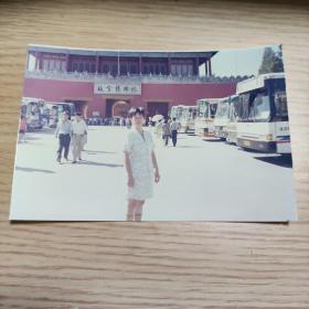 女子在故宫博物院外停车场留影，身后有多辆大客车 彩色老照片