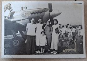 民国时期1947年 衣着打扮高贵大方的年轻女子与小孩在飞机前合影留念